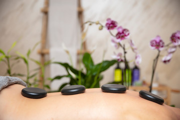 Health spa relaxing stone therapy with hot volcanic stones on back