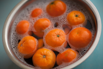 Citrus clementines in soapy water