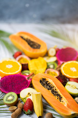 Exotic fruits and tropical leaves on table