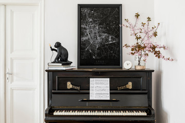Stylish composition at living room interior with black piano, mock up poster map, dried flowers and elegant presonal accessories in modern home decor.