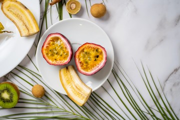 Exotic fruits and tropical leaves on table