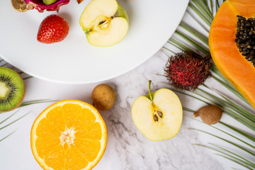 Exotic fruits and tropical leaves on table