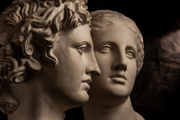 Group gypsum busts of ancient statues human heads for artists on a dark background. Plaster sculptures of antique people faces. Renaissance epoch style. Academic subject. Blank for creativity.