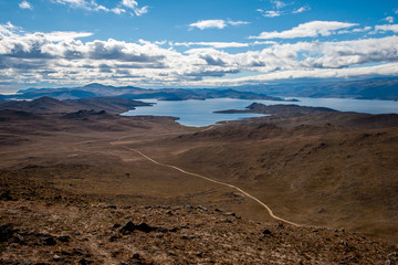 View from a high point on the winding roads between the hills and Lake Baikal. Clouds on the blue...