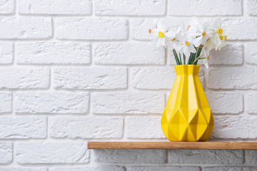 Beautiful daffodil flowers in yellow vase