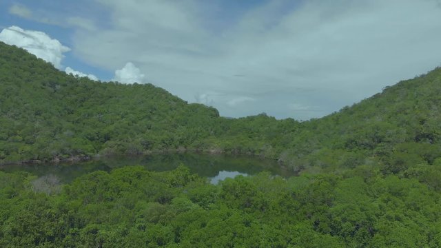 Ascending aerial of a salt lake in Trinidad and Tobago with the mountains of Venezuela juat seven miles in the background