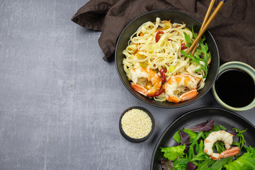 Stir fry noodles with vegetables and shrimps in bowl. Top view. Copy space.