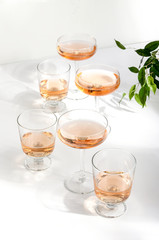 Rose wine in glasses standing on the white table served for a summer party