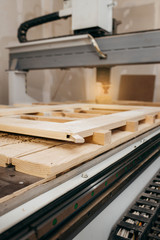 Close-up of cutting wood on a CNC milling machine in garage