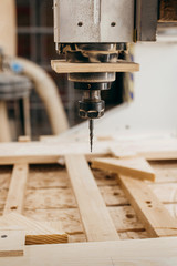 Close-up of cutting wood on a CNC milling machine in garage