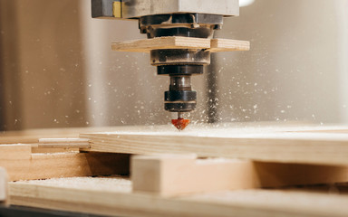Close-up of cutting wood on a CNC milling machine in garage