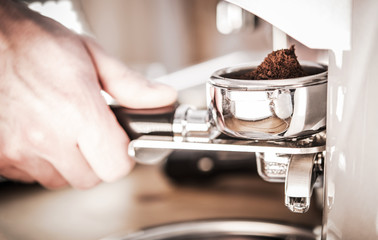 Male Grinding Coffee In Barista Machine.