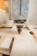 Close-up of cutting wood on a CNC milling machine in garage