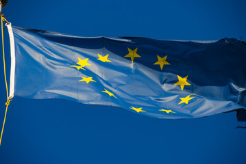 European Union flag blowing in the wind over blue sky background