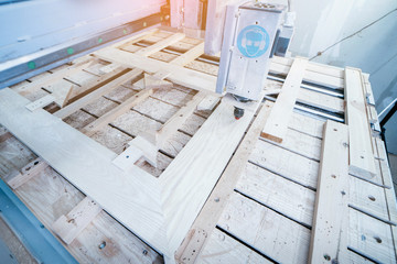 Close-up of cutting wood on a CNC milling machine in garage