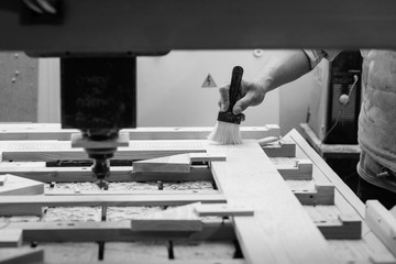 Man cleaning wood  CNC milling machine