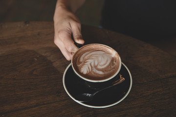 Closeup of hands with coffee cups in a cafe