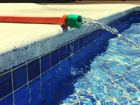 Hose Spraying Water In Swimming Pool