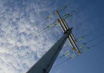 Pillar and power lines against a cloudy sky