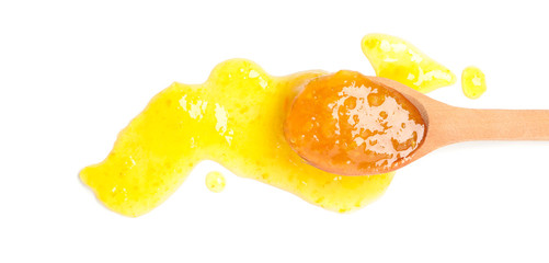 Spoon with apricot jam isolated on white background