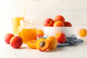 Composition with apricots, juice and jam on white table