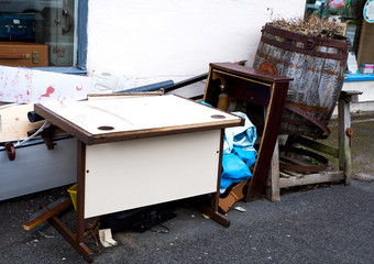 On the british streets of Blackpool England Rubbish, fly tipping garbage and trash left on the side of the street rotting away old wood and metal old barrel and computer desk ruining environment