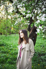 a young girl  in a pink dress walks in the spring garden