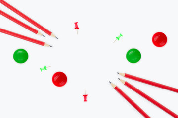 Back to school supplies concept with copy space. Red and green pins, magnets and pencils.