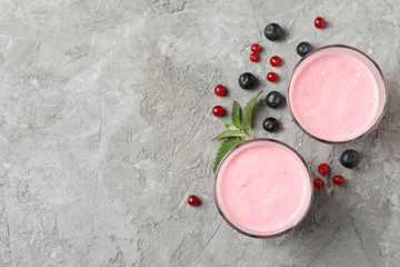 Delicious berry milkshakes on gray table. Summer drink