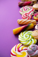 Lollypops kids food on a trend violet color background.