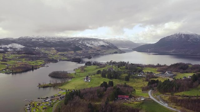 Scenic Norway Landscape. Drone Aerial View of Etne Municipality, Village Settlement by Fjord Under Snow Capped Mountains
