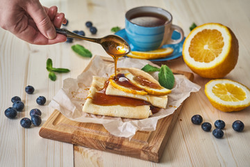 Breakfast. Pancakes with honey, blueberries, orange, mint and a Cup of tea.