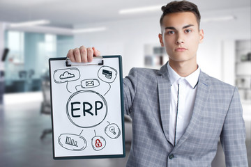 Business, Technology, Internet and network concept. Young businessman working on a virtual screen of the future and sees the inscription: ERP