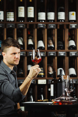 Sommelier looking at red wine glass with beverage