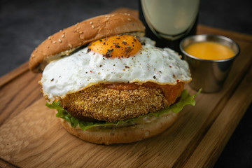 hamburgers with beer on wooden board and dark background