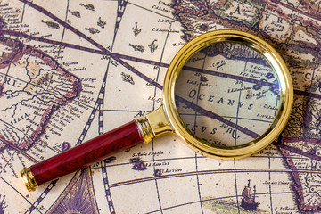 old vintage world map magnifying glass and scroll, travel and tourism concept	