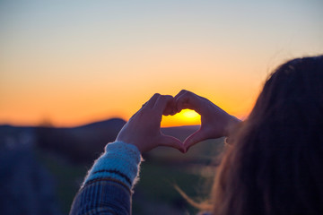 silhouette hand gesture feeling love during sunset