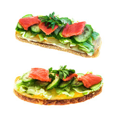 Large toast of rye bread with cheese, cabbage, parsley, fresh cucumber and red fish salmon on white isolated background.