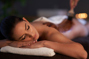 Obraz na płótnie Canvas Relaxed woman receiving a chocolate back massage