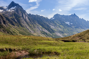 Fototapeta premium ROMEDALEN, NORWAY - 2014 JULY 21. Dreamy mountain valley with green forests, rocks and snow on top of the mountain.