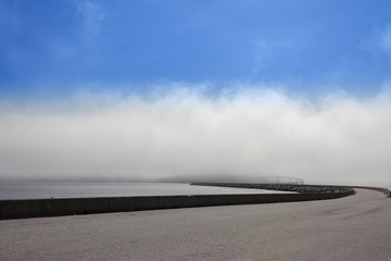 RUNDE, NORWAY - 2014 MAY 29. Runde bridge in Norway surrounded by fog with blue sky.