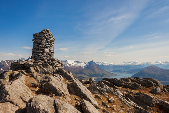 ULSTEINVIK, NORWAY - 2014 APRIL 27. Cairn (a pile of stones) marking mountain hiking trail in Norway.