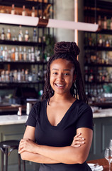 Portrait Of Confident Female Owner Of Restaurant Bar Standing By Counter