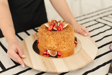 Honey cake. Fig cake. Strawberries on the cake. Cake on a wooden tray. 