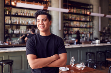 Portrait Of Male Waiter Standing In Bar Restaurant Before Service