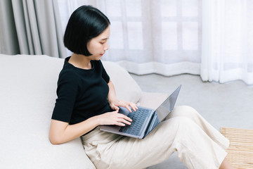 Attractive asian female working with computer laptop at home. Analyzing online data to success business working with computer laptop at home. Work from home concept.