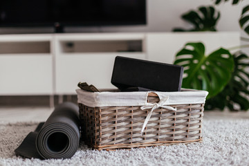 yoga at home. gray yoga mat and black yoga blocks in a nice busket on the curpet in a white light...