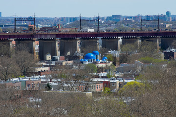 Fototapeta na wymiar Astoria Queens New York Neighborhood Skyline with Residential Buildings and Domes from a Greek Orthodox Church with the Hell Gate Railroad Bridge in the background
