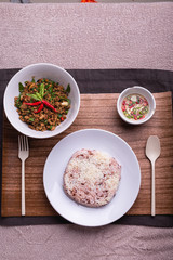 Stir fried minced pork with basil served with steamed jasmin rice and Riceberry, Pad kra pao.
