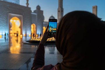 Woman taking photos with a smart phone of a mosque at sunset | Abu Dhabi Sheik Zayed Mosque | Beautiful islamic architecture | Tourist attraction